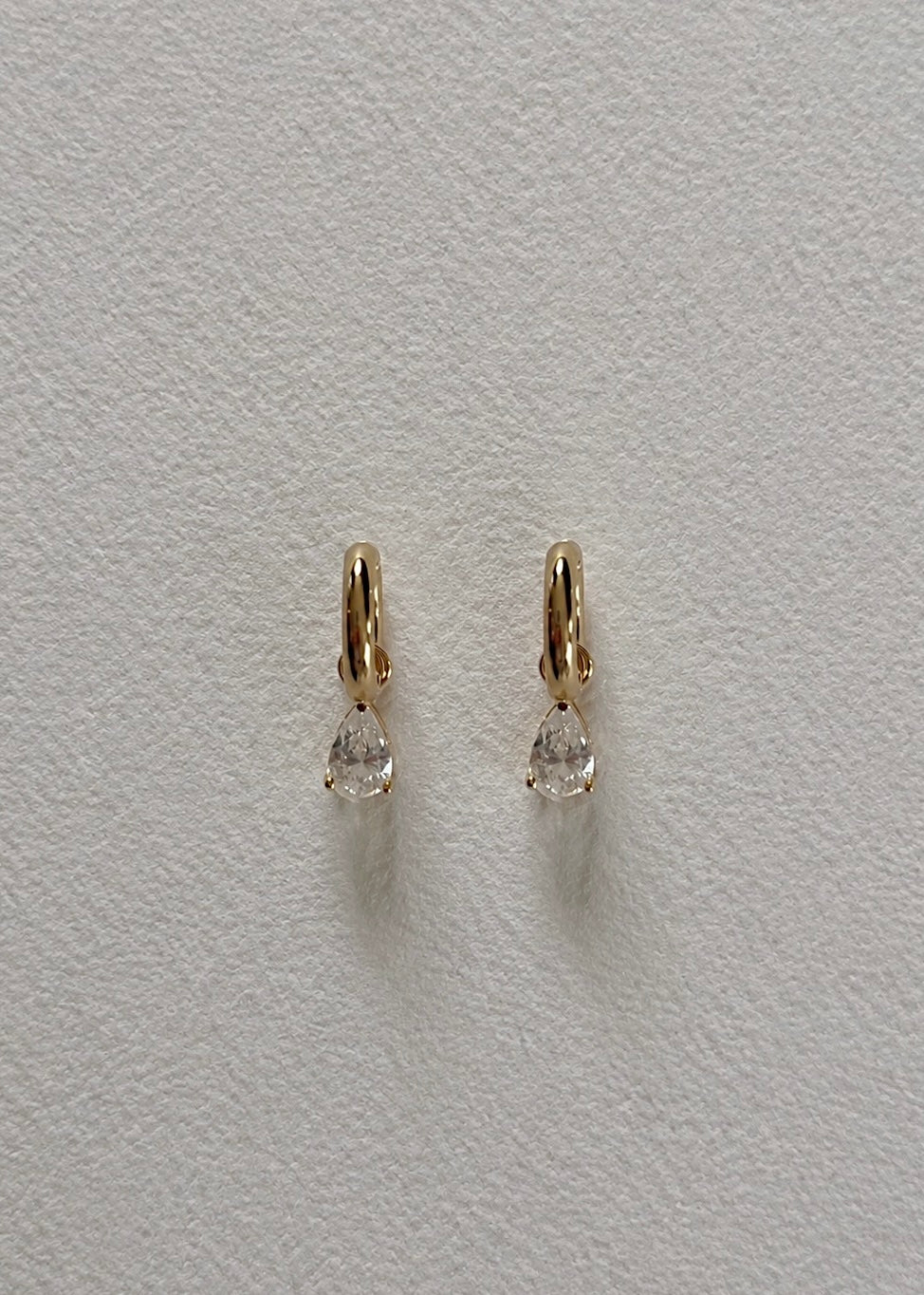 Gold huggie earrings with high shine finish featuring a timeless minimalist design for women