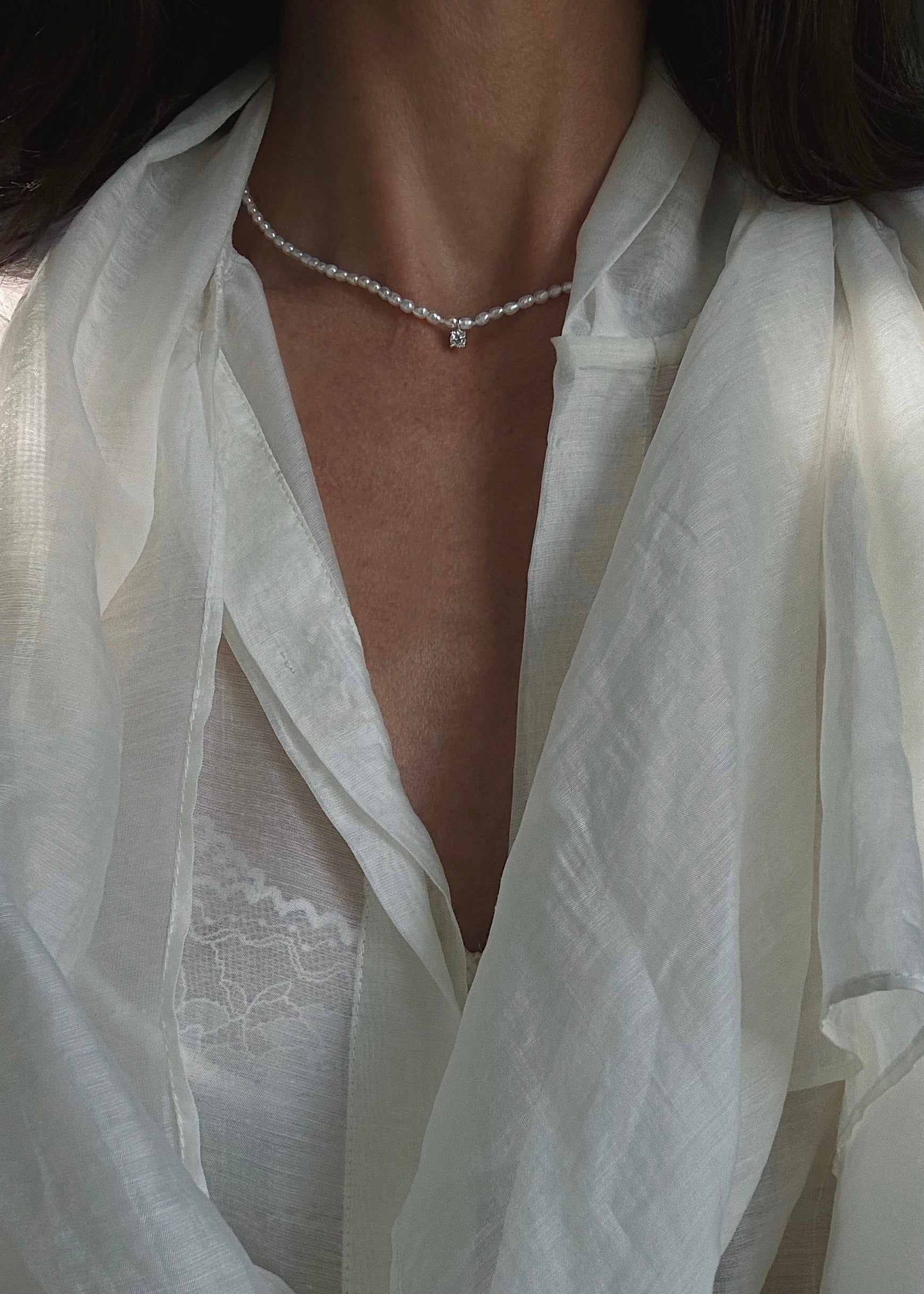  Close-up of a freshwater pearl necklace crafted in sterling silver 925 with semi-precious stone pendant.