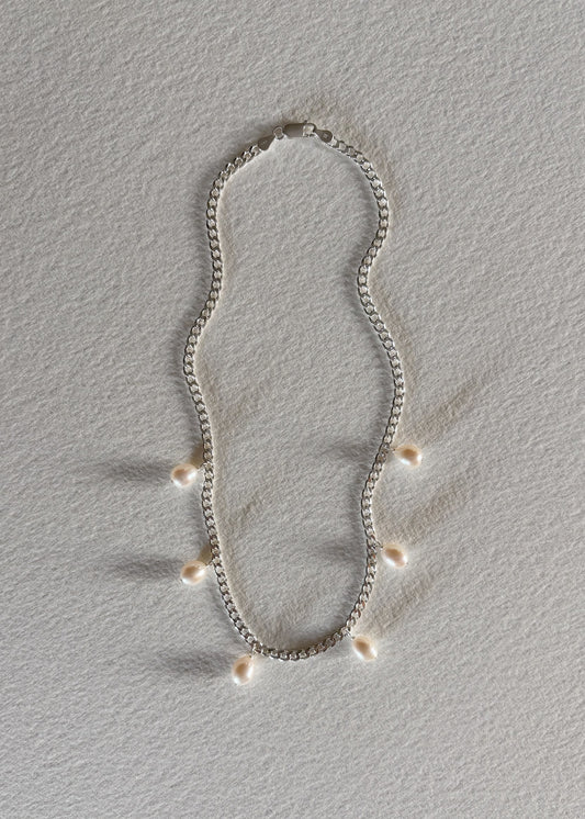 Silver necklace crafted in 925 sterling silver, adorned with luminous freshwater pearls, featuring a timeless design that embodies modern elegance and refined simplicity.