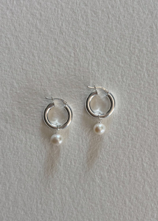 Silver earrings crafted in 925 sterling silver, adorned with luminous freshwater pearls, featuring a timeless design that embodies modern elegance and refined simplicity.