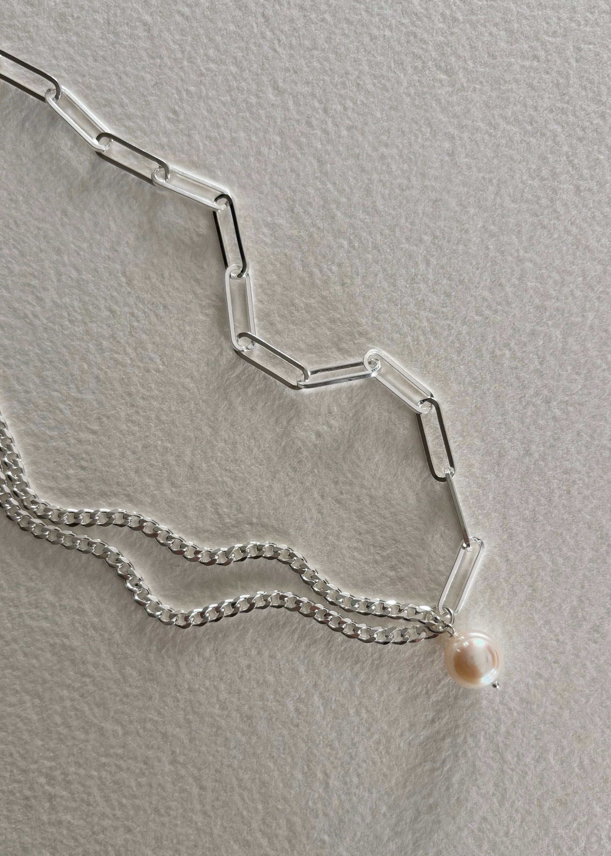 Silver necklace crafted in 925 sterling silver, adorned with luminous freshwater pearls, featuring a timeless design that embodies modern elegance and refined simplicity.